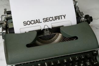 a close up of a typewriter with a paper that says social security by Markus Winkler courtesy of Unsplash.